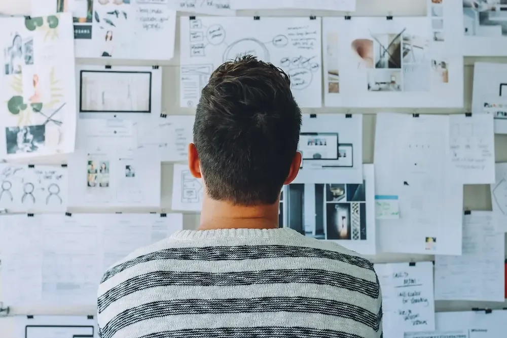 Man analysing a wall covered with detailed plans and steps to follow after Company Registration in Ireland.