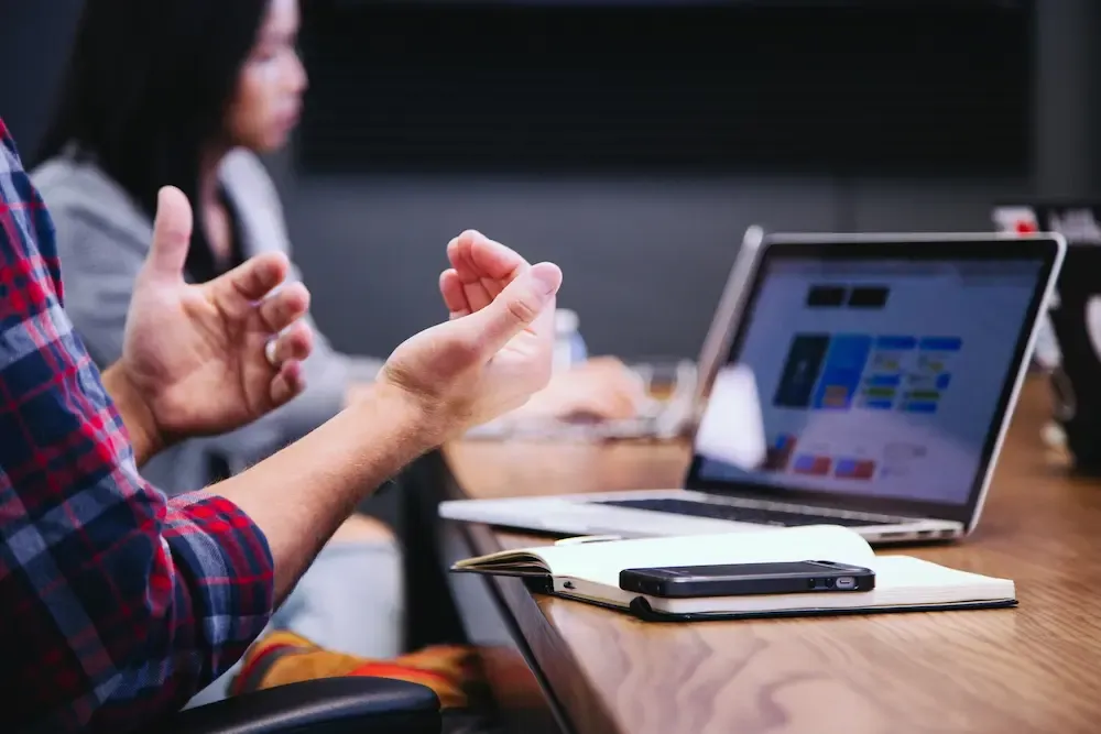 Hands gesturing in front of a laptop, indicating guidance for Registration of Beneficial Owners.