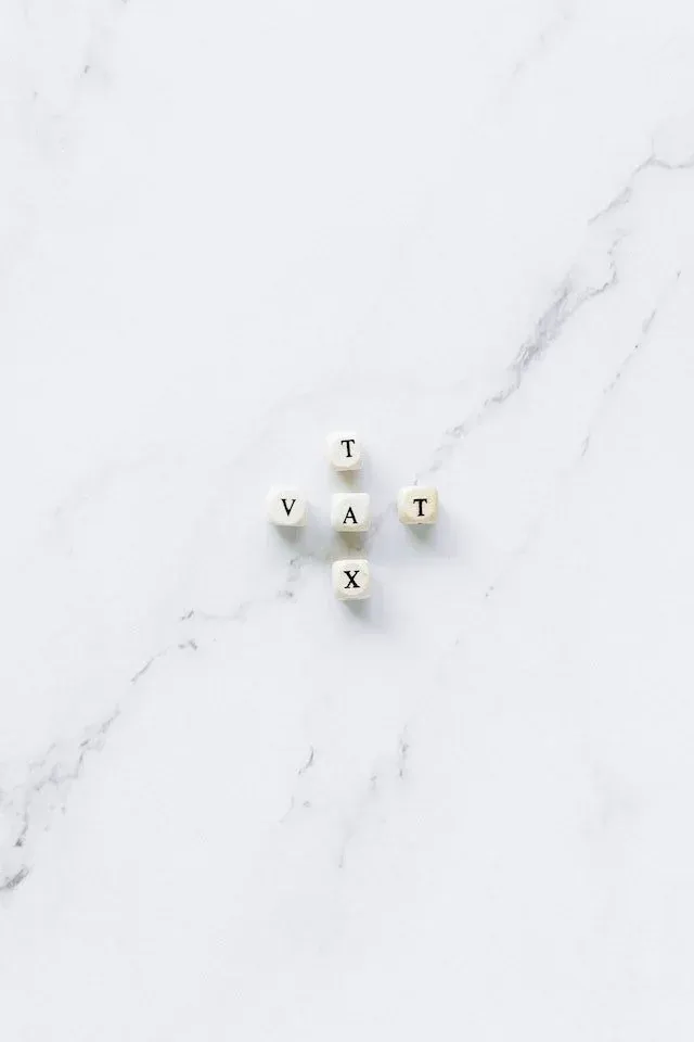 Letter tiles spelling 'VAT' and 'TAX' on a marble table, indicating our comprehensive guidance on VAT Returns in Ireland.