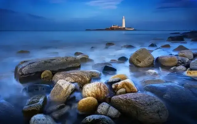 Rocky bay covered in mist with a view of the Lighthouse, symbolising support for Motor Travel and Subsistence expenses.